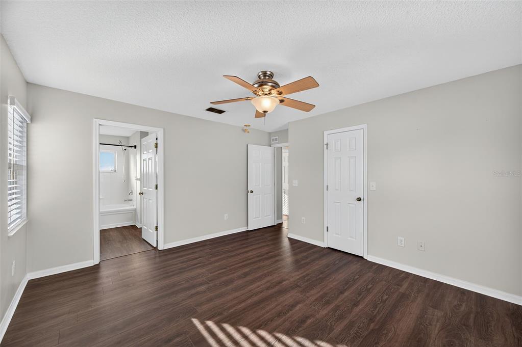 28632 Seashell Court Wesley Chapel, FL 33545 - Photo 41 of 60 a view of an empty room with wooden floor and a ceiling fan