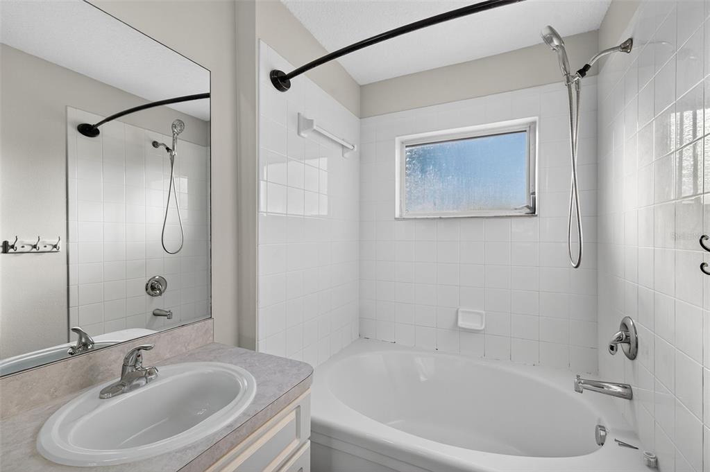 28632 Seashell Court Wesley Chapel, FL 33545 - Photo 44 of 60 a white bath tub sitting next to a white sink and a mirror