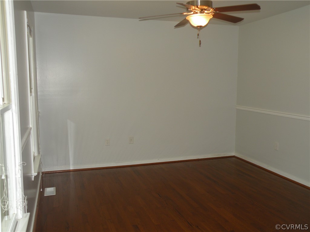 12436 Walkes Quarter Road Chesterfield, VA 23838 - Photo 7 of 31 an empty room with a chandelier fan and wooden floor