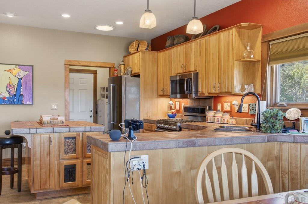 415 Riata Drive Trinidad, CO 81082 - Photo 33 of 61 a kitchen with stainless steel appliances granite countertop a sink a stove and a microwave