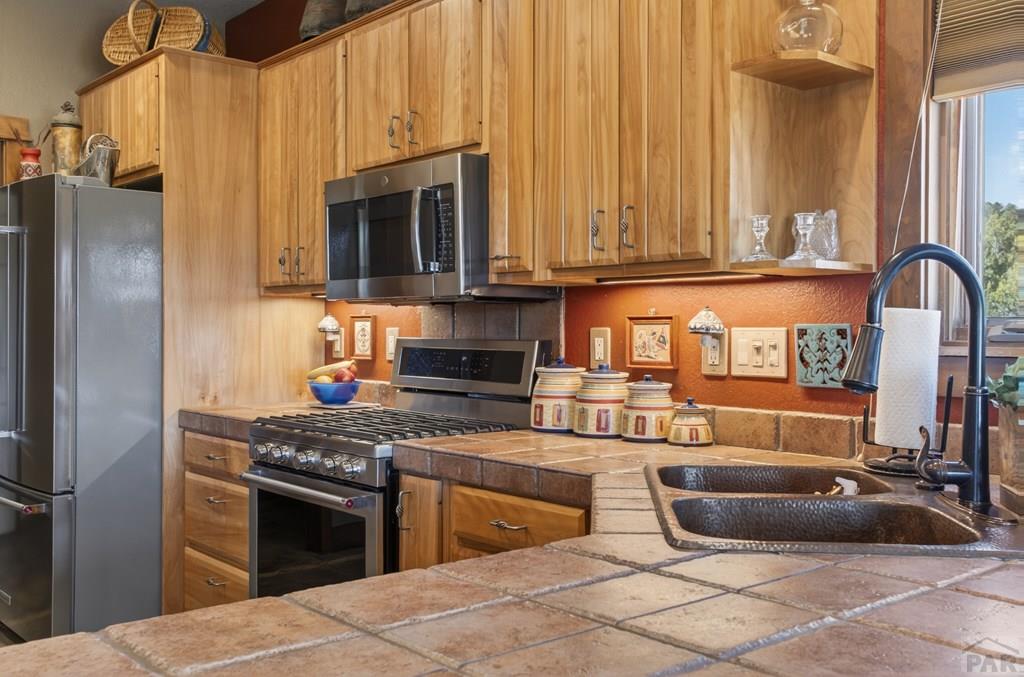 415 Riata Drive Trinidad, CO 81082 - Photo 35 of 61 a kitchen with stainless steel appliances granite countertop a stove a sink and a microwave