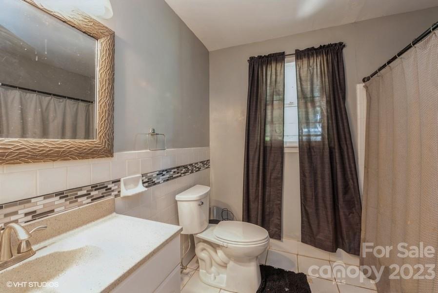 6925 Random Place Charlotte, NC 28215 - Photo 23 of 31 a bathroom with a sink a toilet a mirror and shower