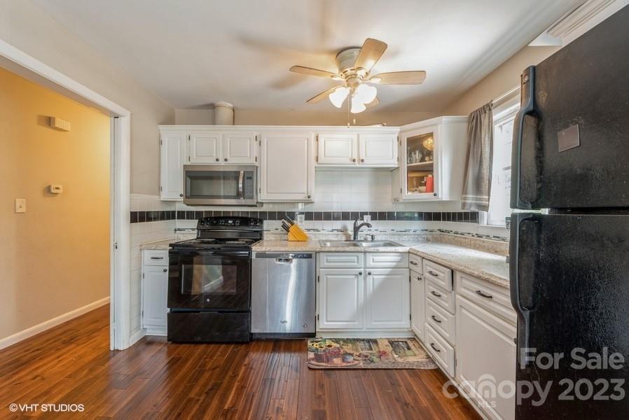 6925 Random Place Charlotte, NC 28215 - Photo 7 of 31 a kitchen with stainless steel appliances a stove a sink and white cabinets