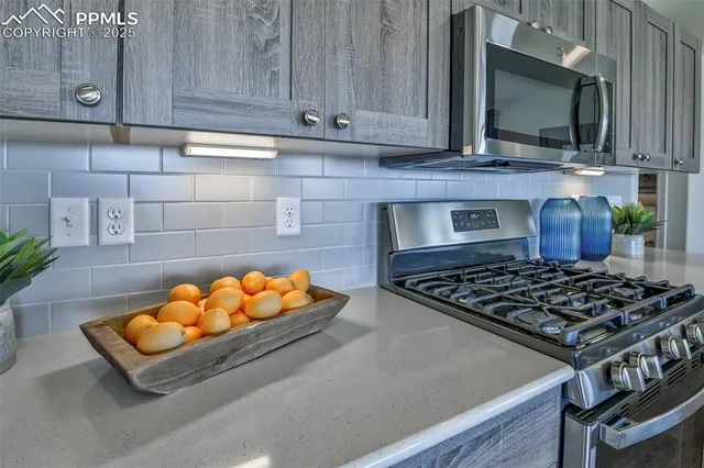 a kitchen with stainless steel appliances granite countertop a stove and a microwave
