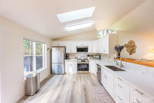 a large kitchen with a large window and stainless steel appliances
