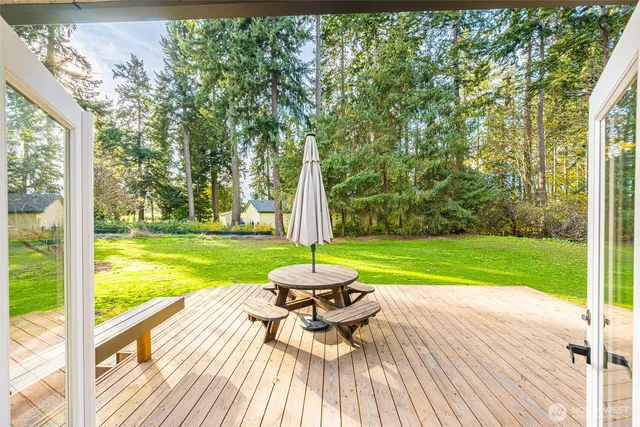 a view of a patio with a table chairs and a yard