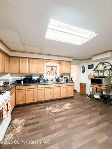 a large white kitchen with stainless steel appliances granite countertop a stove and a sink