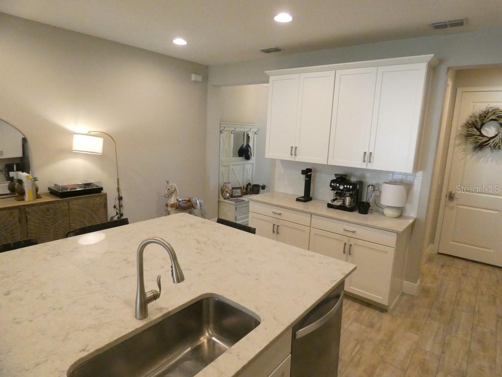 1505 Sunset Wind Loop Oldsmar, FL 34677 - Photo 12 of 36 a kitchen with stainless steel appliances granite countertop a sink a stove and white cabinets