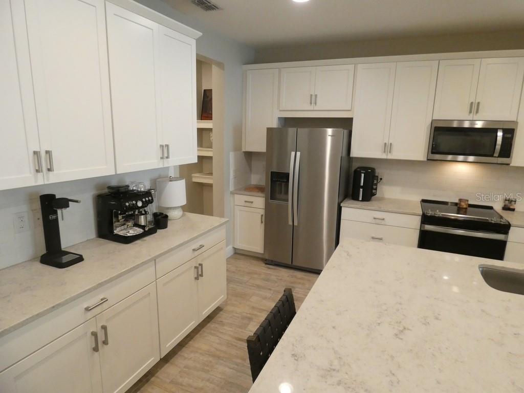 1505 Sunset Wind Loop Oldsmar, FL 34677 - Photo 4 of 36 a kitchen with stainless steel appliances white cabinets and a refrigerator