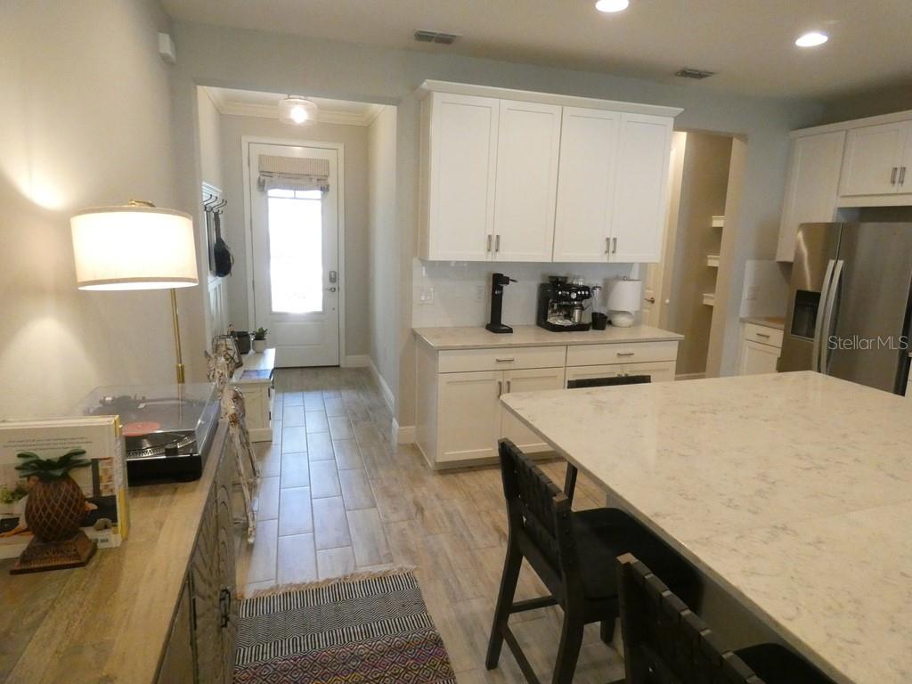 1505 Sunset Wind Loop Oldsmar, FL 34677 - Photo 8 of 36 a kitchen with a table chairs refrigerator and cabinets