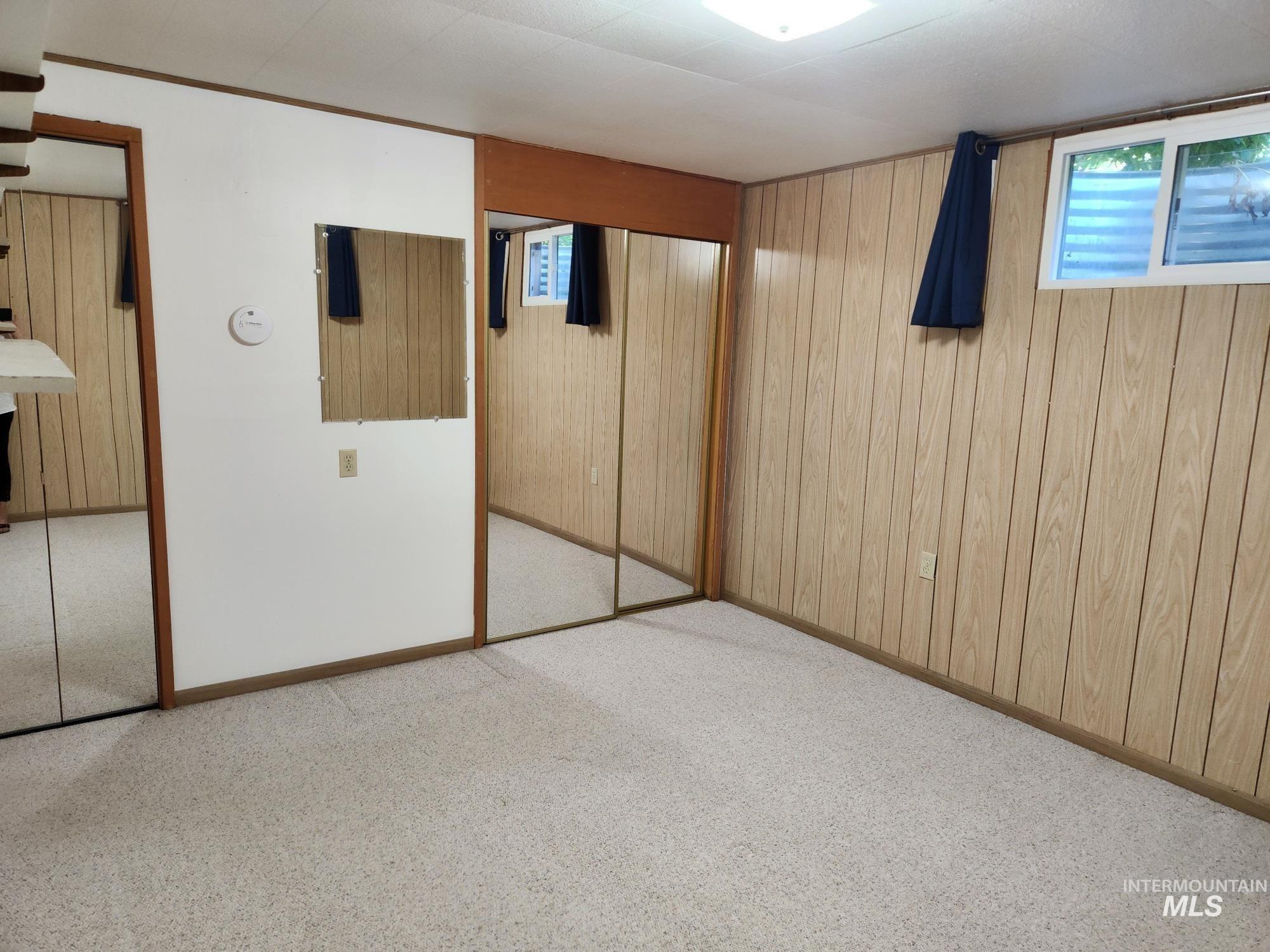 367 Woodland Road Kamiah, ID 83536 - Photo 28 of 49 Unfurnished bedroom with wood walls, a closet, and carpet floors