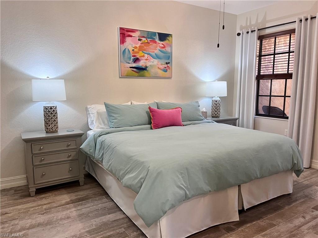 9092 Chula Vista Street, Unit 11003 Naples, FL 34113 - Photo 14 of 42 a bedroom with a bed and a large window