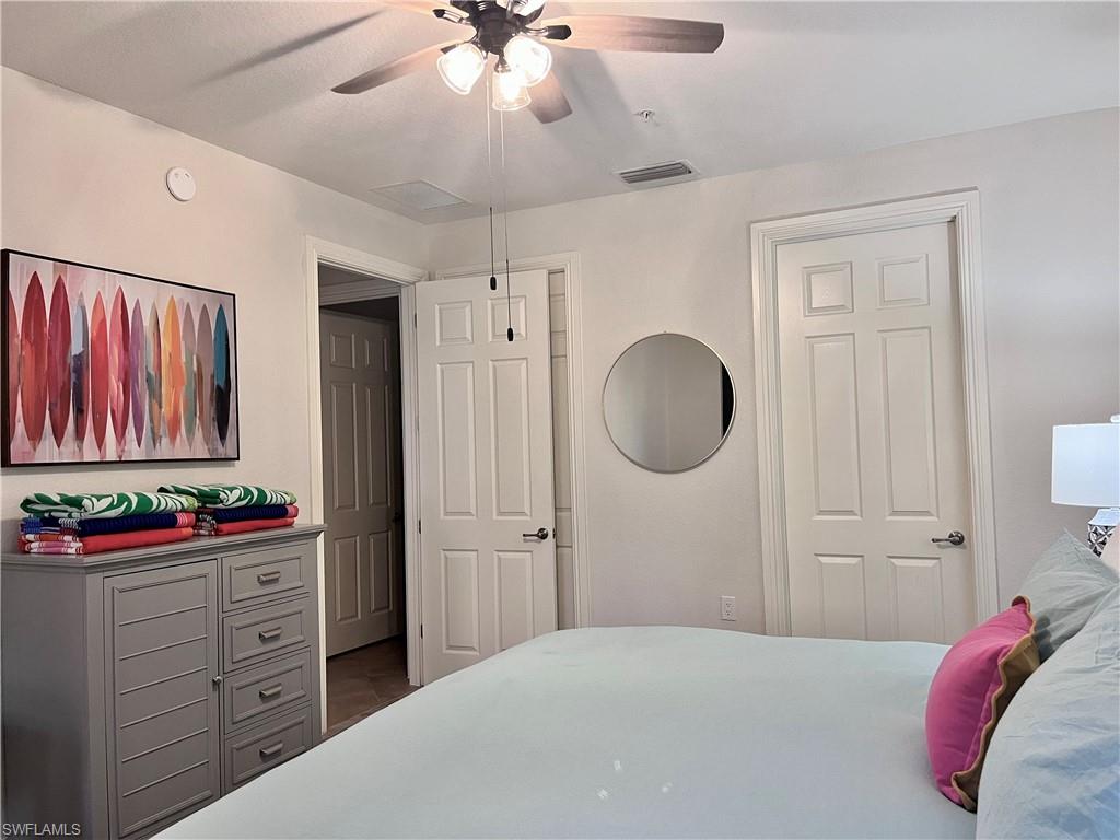 9092 Chula Vista Street, Unit 11003 Naples, FL 34113 - Photo 16 of 42 a bedroom with a bed and a chandelier