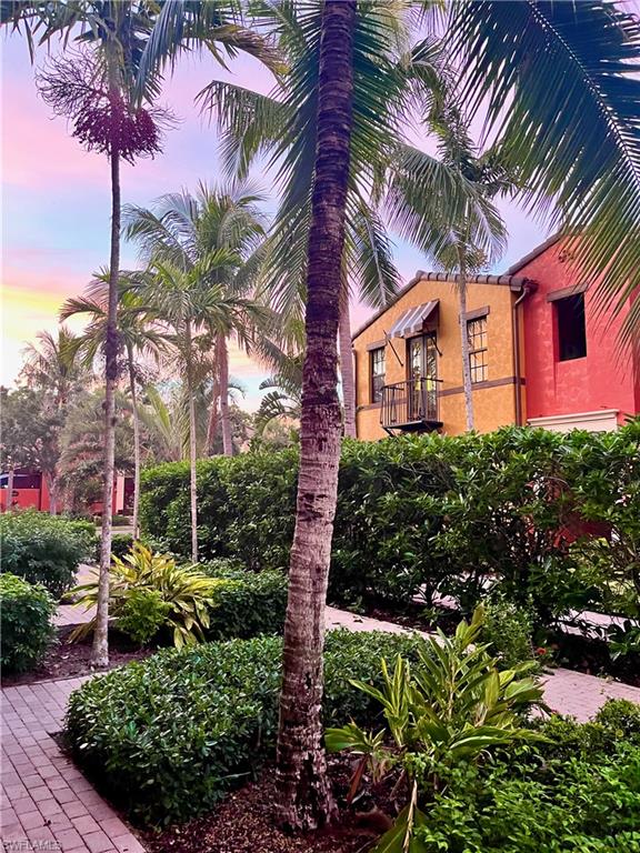 9092 Chula Vista Street, Unit 11003 Naples, FL 34113 - Photo 22 of 42 a front view of a house with a garden