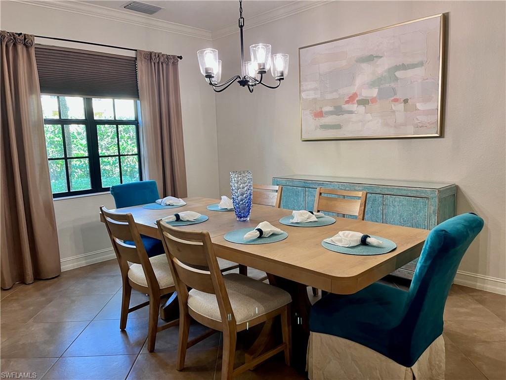 9092 Chula Vista Street, Unit 11003 Naples, FL 34113 - Photo 3 of 42 a view of a dining room with furniture a chandelier and wooden floor