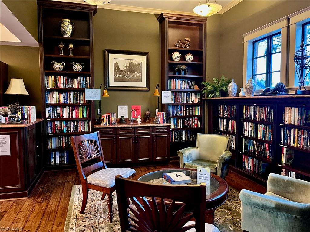 9092 Chula Vista Street, Unit 11003 Naples, FL 34113 - Photo 36 of 42 a living room with furniture a rug and a book shelf