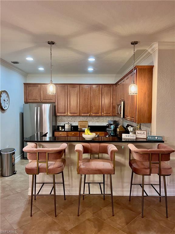 9092 Chula Vista Street, Unit 11003 Naples, FL 34113 - Photo 6 of 42 a kitchen with stainless steel appliances granite countertop table chairs sink and cabinets