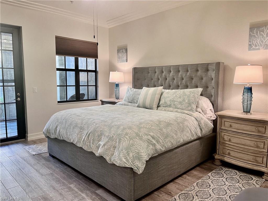 9092 Chula Vista Street, Unit 11003 Naples, FL 34113 - Photo 7 of 42 a large bed sitting in a bedroom next to a window and a lamp