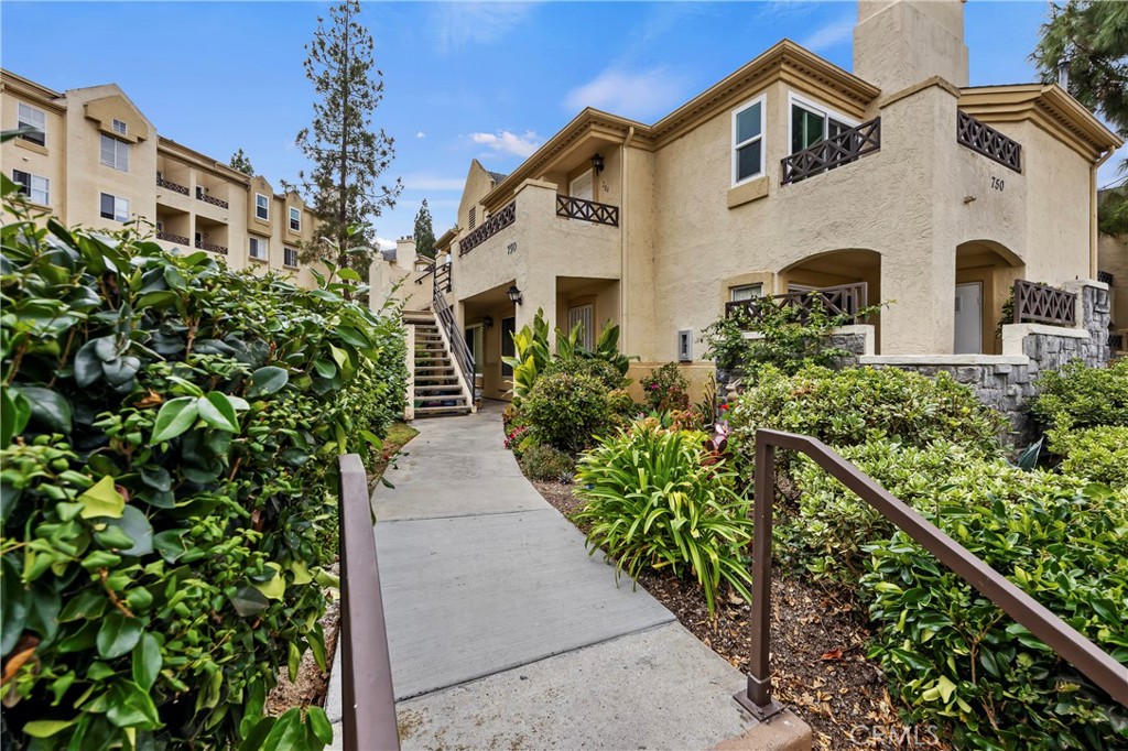 750 Brookstone Road, Unit 104 Chula Vista, CA 91913 - Photo 1 of 1 a front view of a house with a yard and potted plants