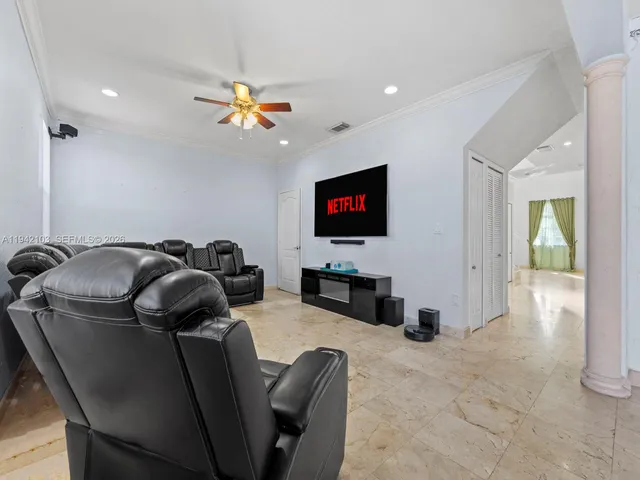 a living room with furniture a flat screen tv and a chandelier