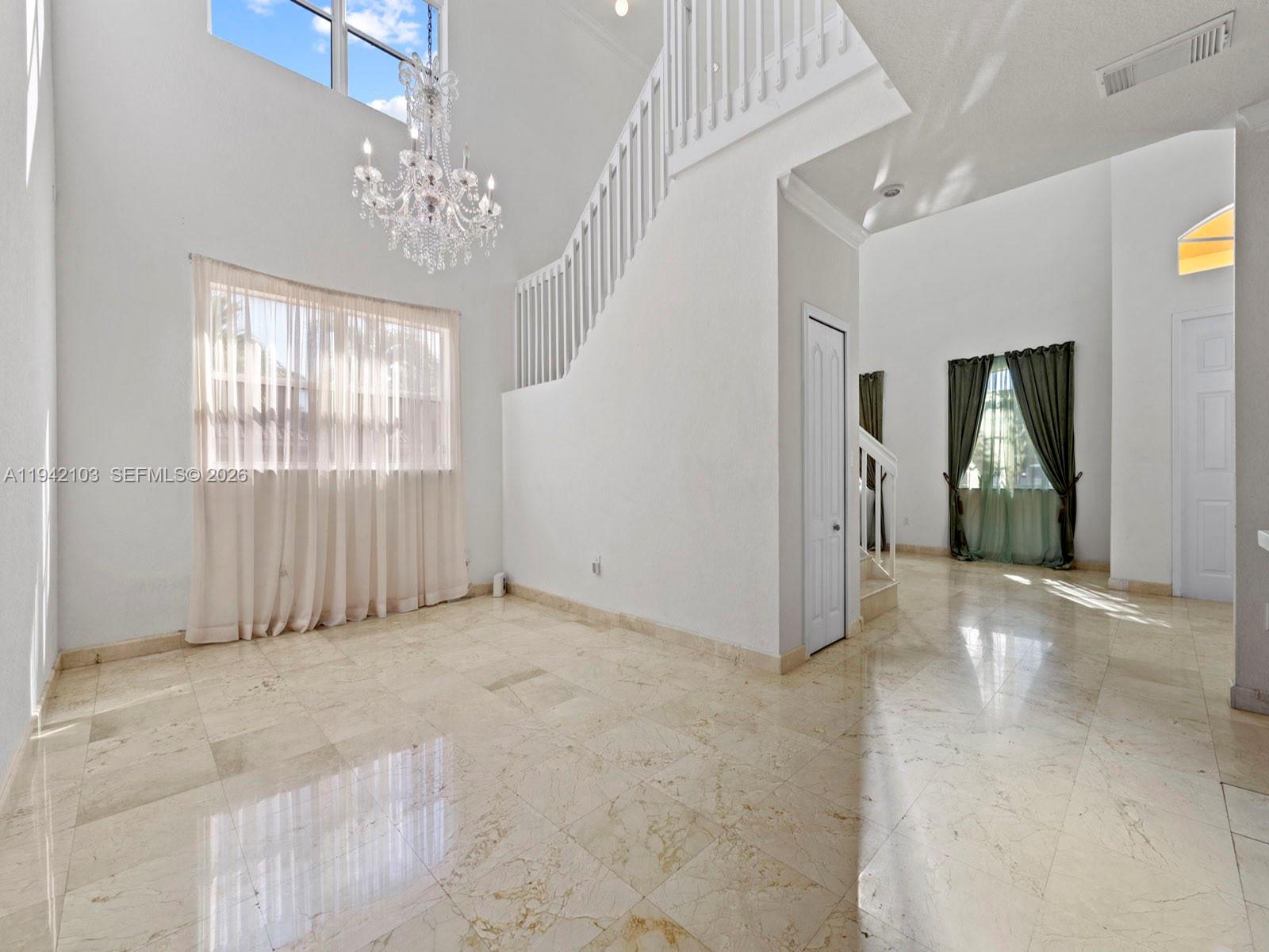 16421 Southwest 64th Terrace Miami, FL 33193 - Photo 4 of 45 an empty room with windows and entrance