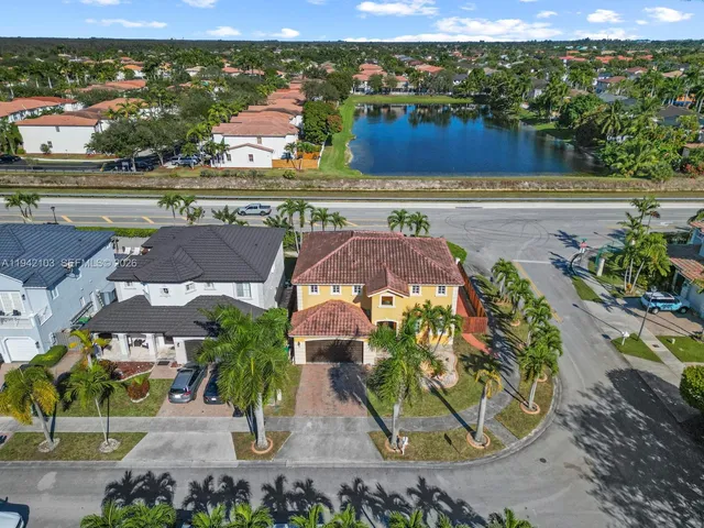 an aerial view of residential houses with outdoor space and lake view