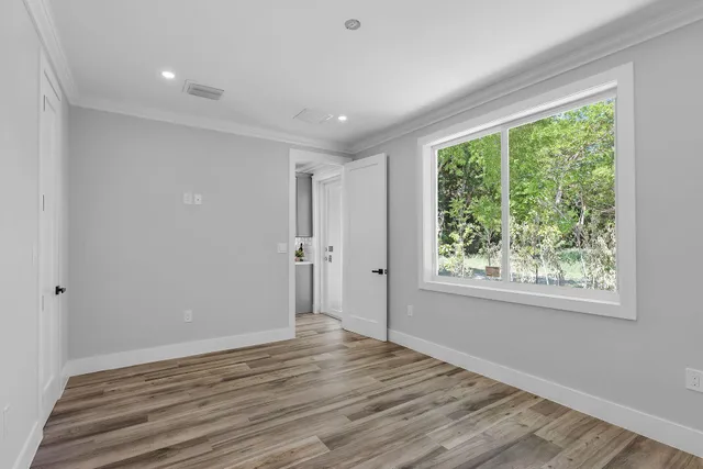 a view of a room with wooden floor and a bathroom
