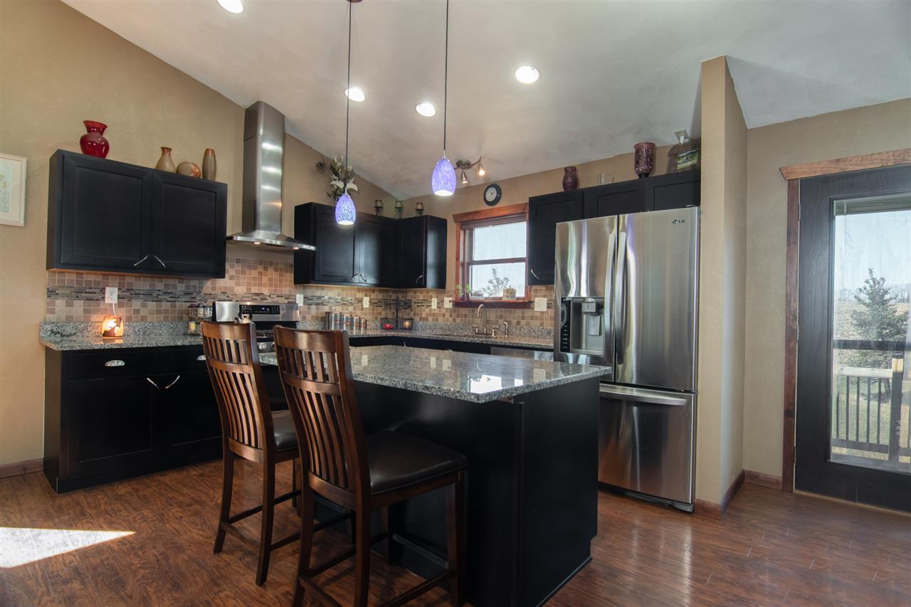 10024 Wheeler Road Durand, IL 61024 - Photo 7 of 25 a kitchen with stainless steel appliances granite countertop a refrigerator a sink a stove a microwave a dining table and chairs