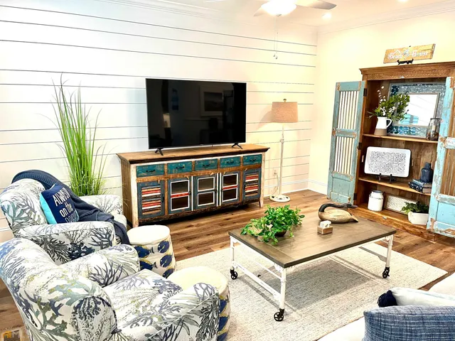 a living room with furniture a large window and a chandelier