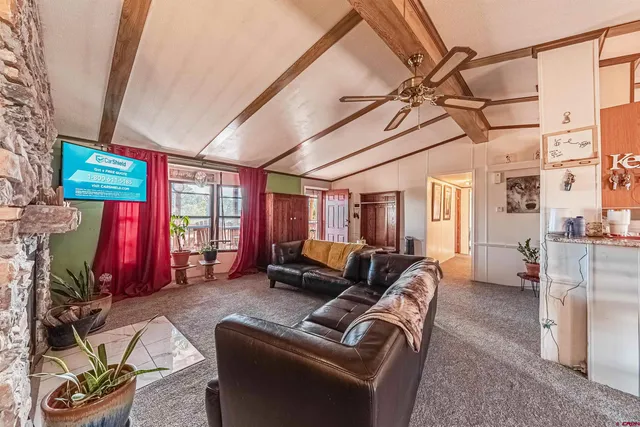 a living room with furniture a flat screen tv and a window