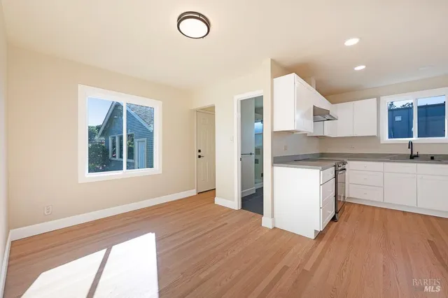 a kitchen with a refrigerator and white cabinets