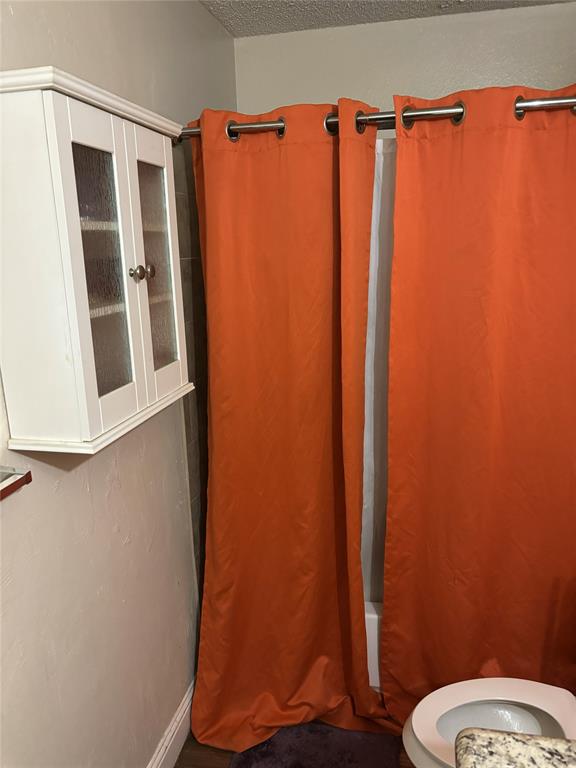 2200 East Trinity Mills Road, Unit 208 Carrollton, TX 75006 - Photo 18 of 23 a bathroom with a shower curtain and a toilet