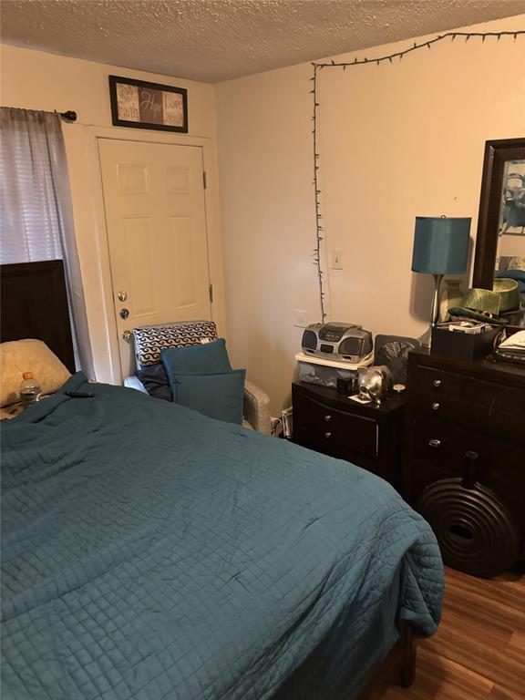 2200 East Trinity Mills Road, Unit 208 Carrollton, TX 75006 - Photo 20 of 23 a bedroom with a bed and a flat tv screen on the dresser