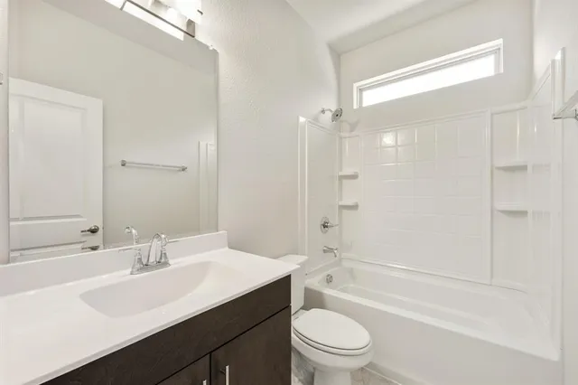 a large white kitchen with lots of counter space a sink and stainless steel appliances