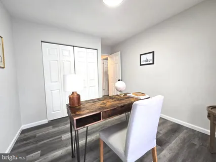 a view of a workspace with furniture and a window