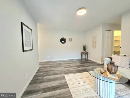 a kitchen with a sink dishwasher a stove and white cabinets with wooden floor