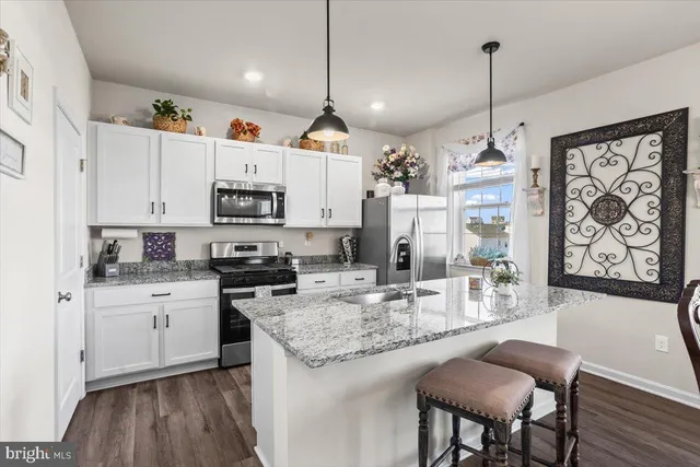 a kitchen with stainless steel appliances granite countertop a stove refrigerator and cabinets