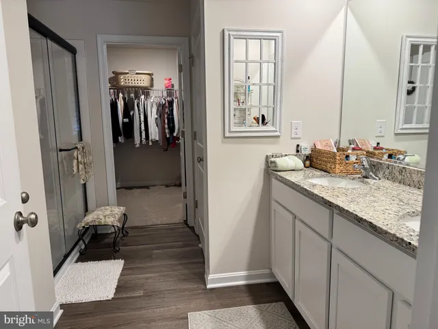 a bathroom with a granite countertop sink a mirror and a bathtub