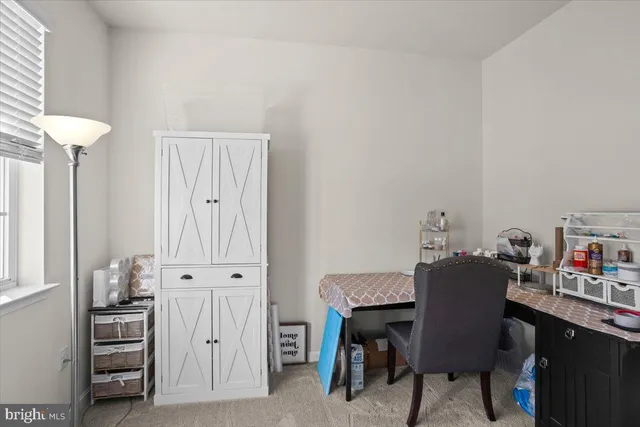 a view of a workspace with furniture and a window