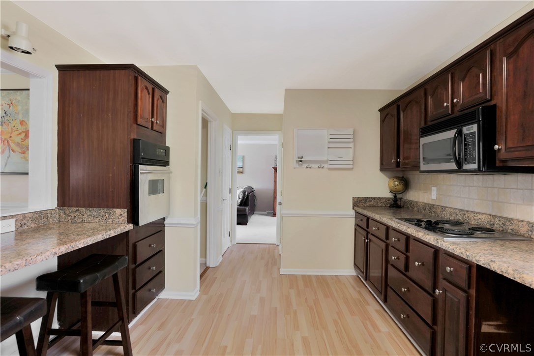 11451 Driscoll Road Chester, VA 23831 - Photo 6 of 25 a kitchen with stainless steel appliances granite countertop a stove refrigerator and a microwave oven