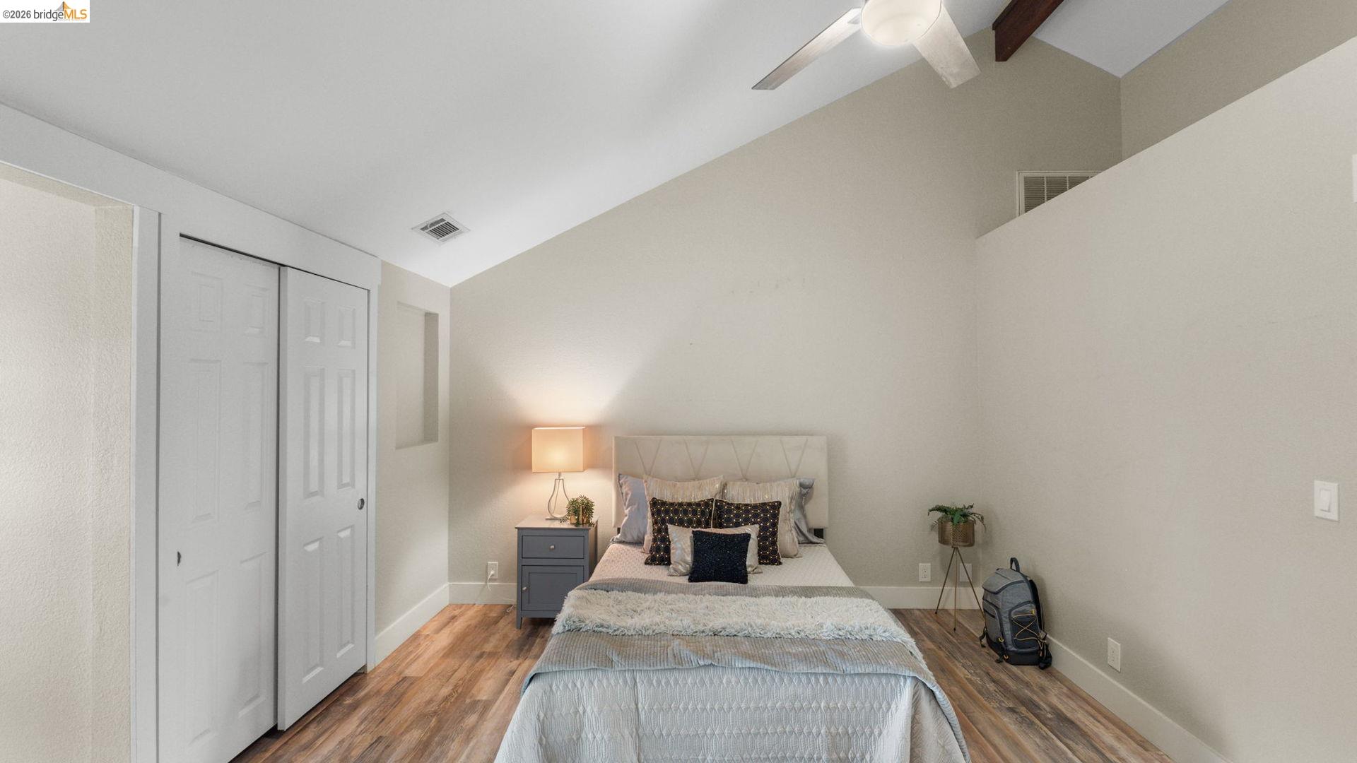 700 Brownstone Road Oakley, CA 94561 - Photo 27 of 58 Bedroom featuring vaulted ceilings with exposed wood beams, wood-finish flooring, a ceiling fan, and a bi-fold closet