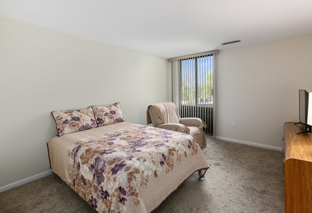1008 Paradise Road, Unit 2E Swampscott, MA 01907 - Photo 15 of 22 a bed sitting in a bedroom next to a window