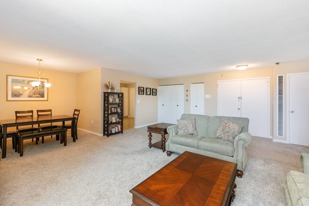 1008 Paradise Road, Unit 2E Swampscott, MA 01907 - Photo 3 of 22 a living room with furniture and a dining table with bookshelf