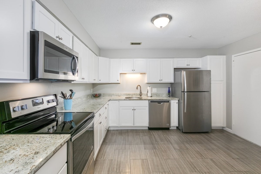 1008 Paradise Road, Unit 2E Swampscott, MA 01907 - Photo 6 of 22 a kitchen with a sink stove and refrigerator