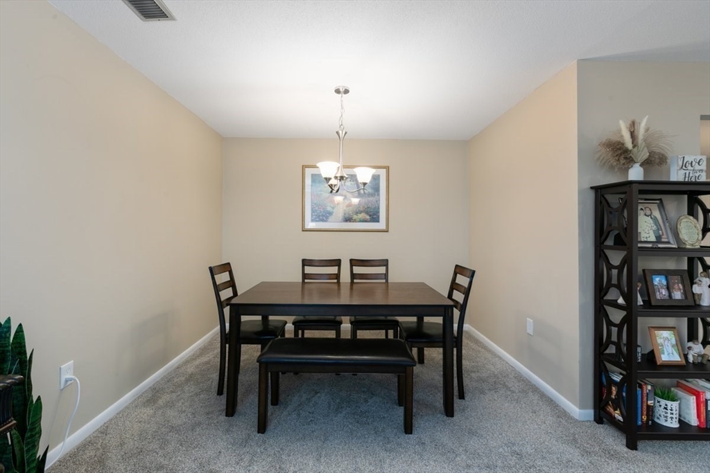 1008 Paradise Road, Unit 2E Swampscott, MA 01907 - Photo 7 of 22 a view of a dining room with furniture and a book shelf