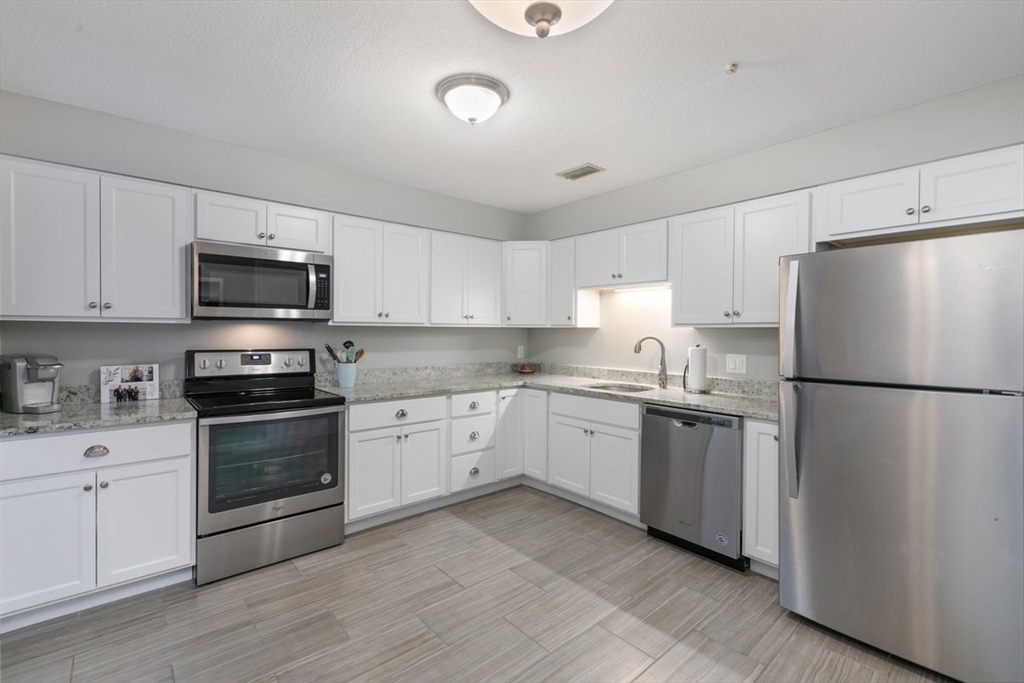 1008 Paradise Road, Unit 2E Swampscott, MA 01907 - Photo 8 of 22 a kitchen with granite countertop white cabinets and stainless steel appliances