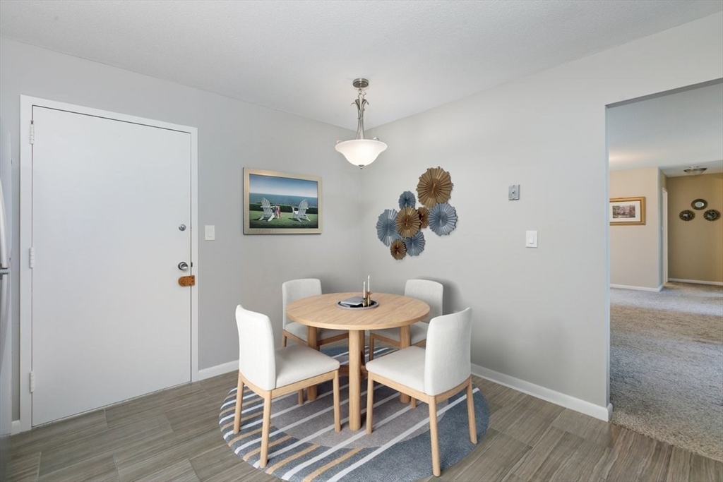 1008 Paradise Road, Unit 2E Swampscott, MA 01907 - Photo 10 of 22 a dining room with furniture wooden floor a rug and a painting