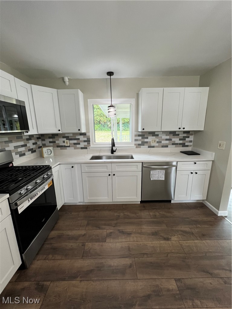 1715 Toepfer Road Akron, OH 44312 - Photo 3 of 49 Kitchen featuring dark wood-type flooring, sink, range, hanging light fixtures, and dishwashing machine