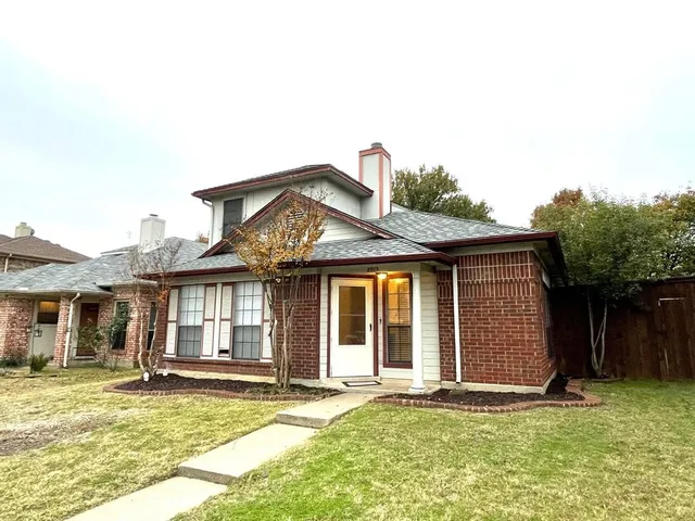 a front view of a house with a garden and yard