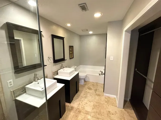 a bathroom with a sink a mirror a vanity and shower